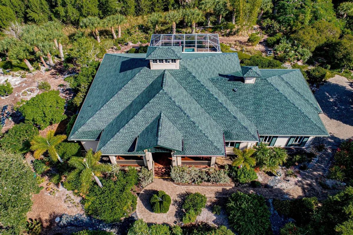 Large green shingle home in the Sanibel preserve