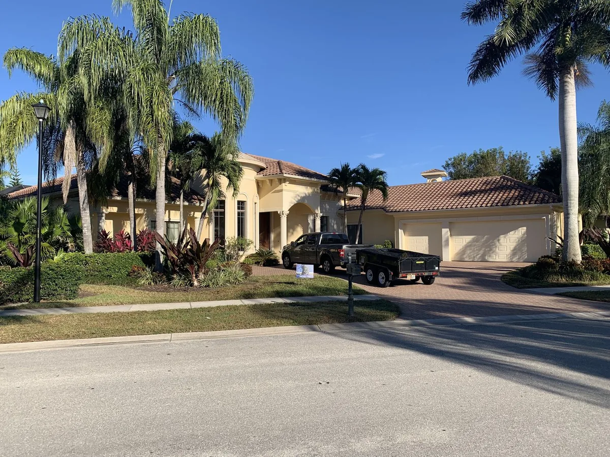 Blue Dog crew working on a cream Mediterranean estate, company sign in the yard