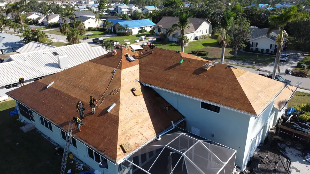 Blue Dog crew in harnesses on a stripped deck the morning after tear-off