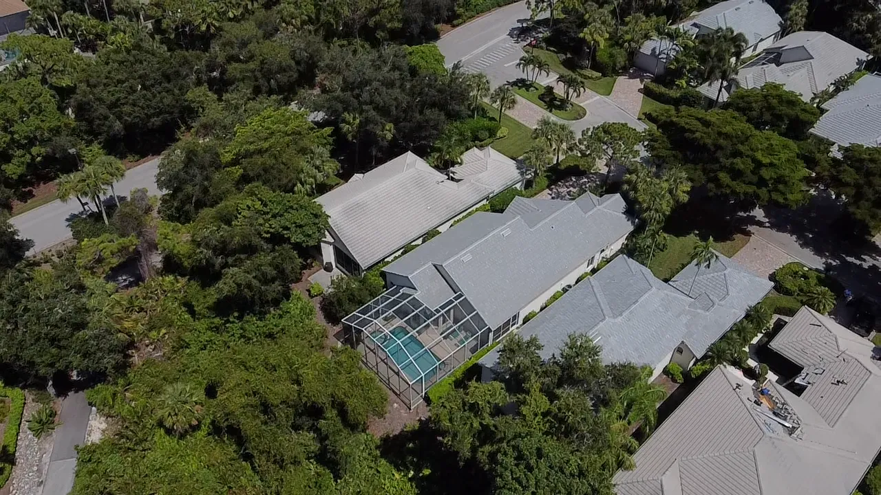 Gray flat tile roof and pool enclosure on a Bonita Springs home