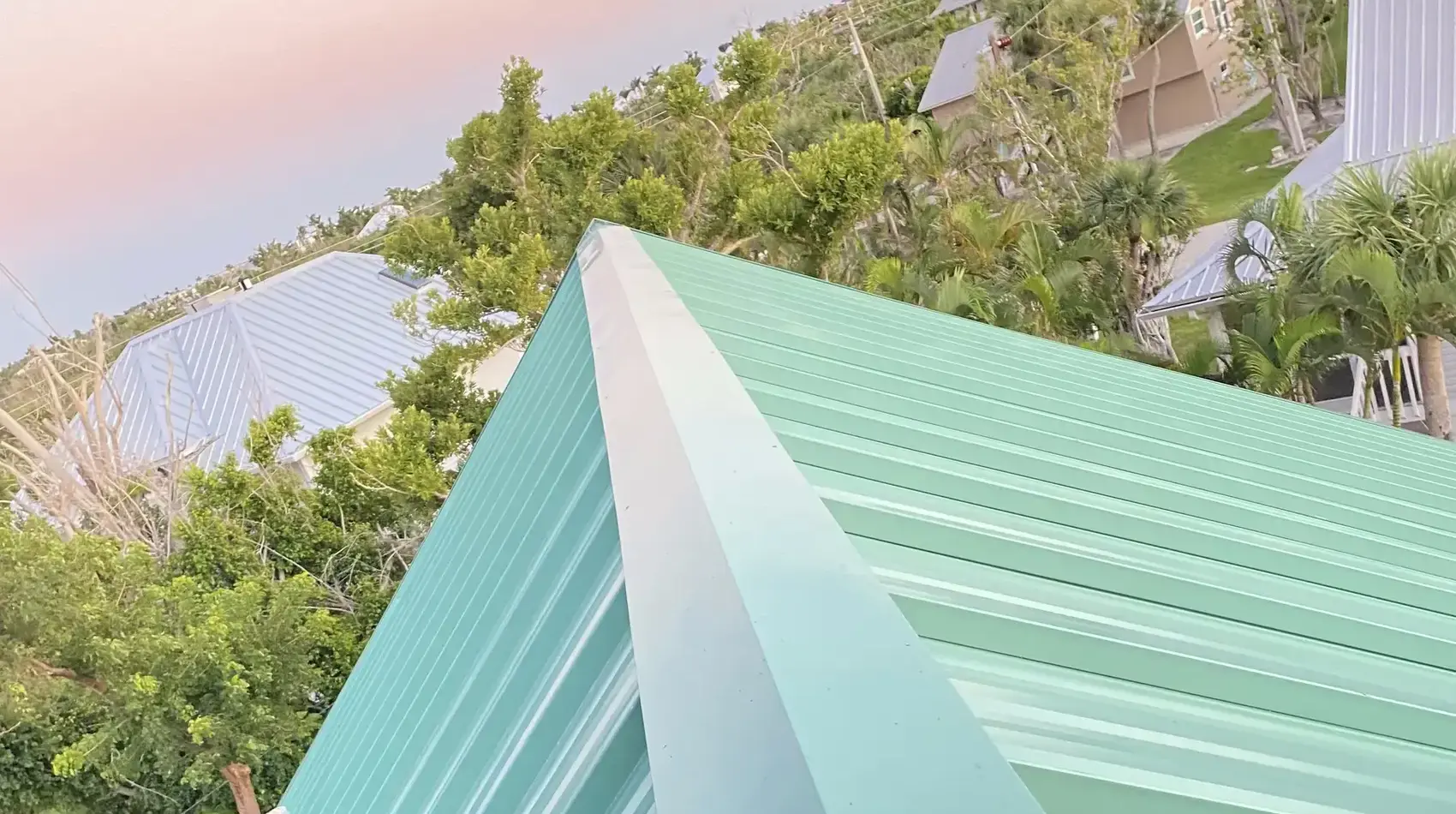 Seafoam standing-seam metal roof on a Sanibel home at sunset