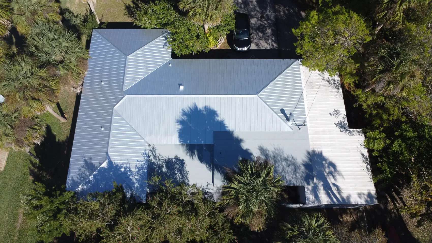 Top-down view of a finished white metal roof on an Estero home