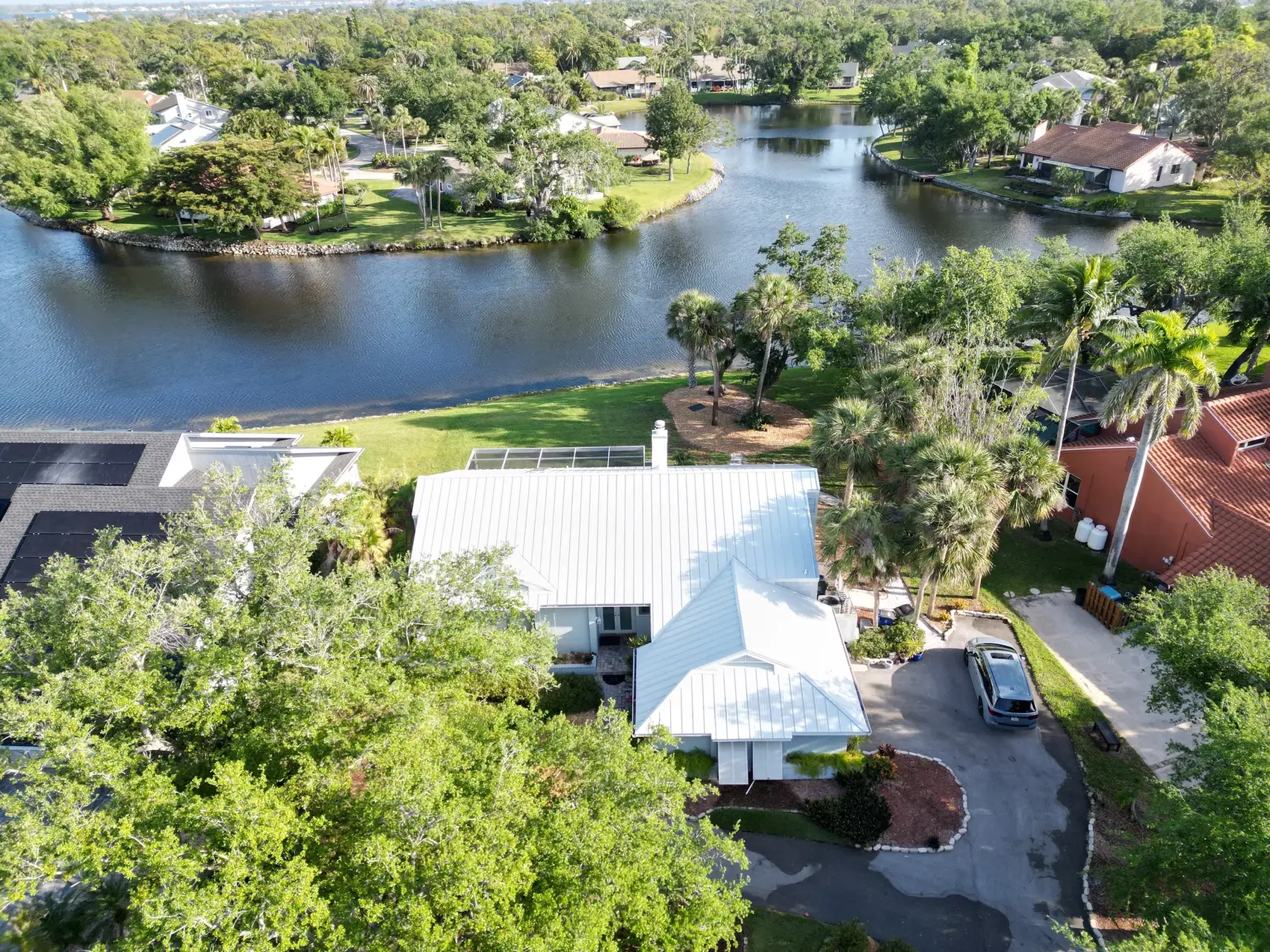 White standing-seam metal roof on a lakefront Punta Gorda-area home
